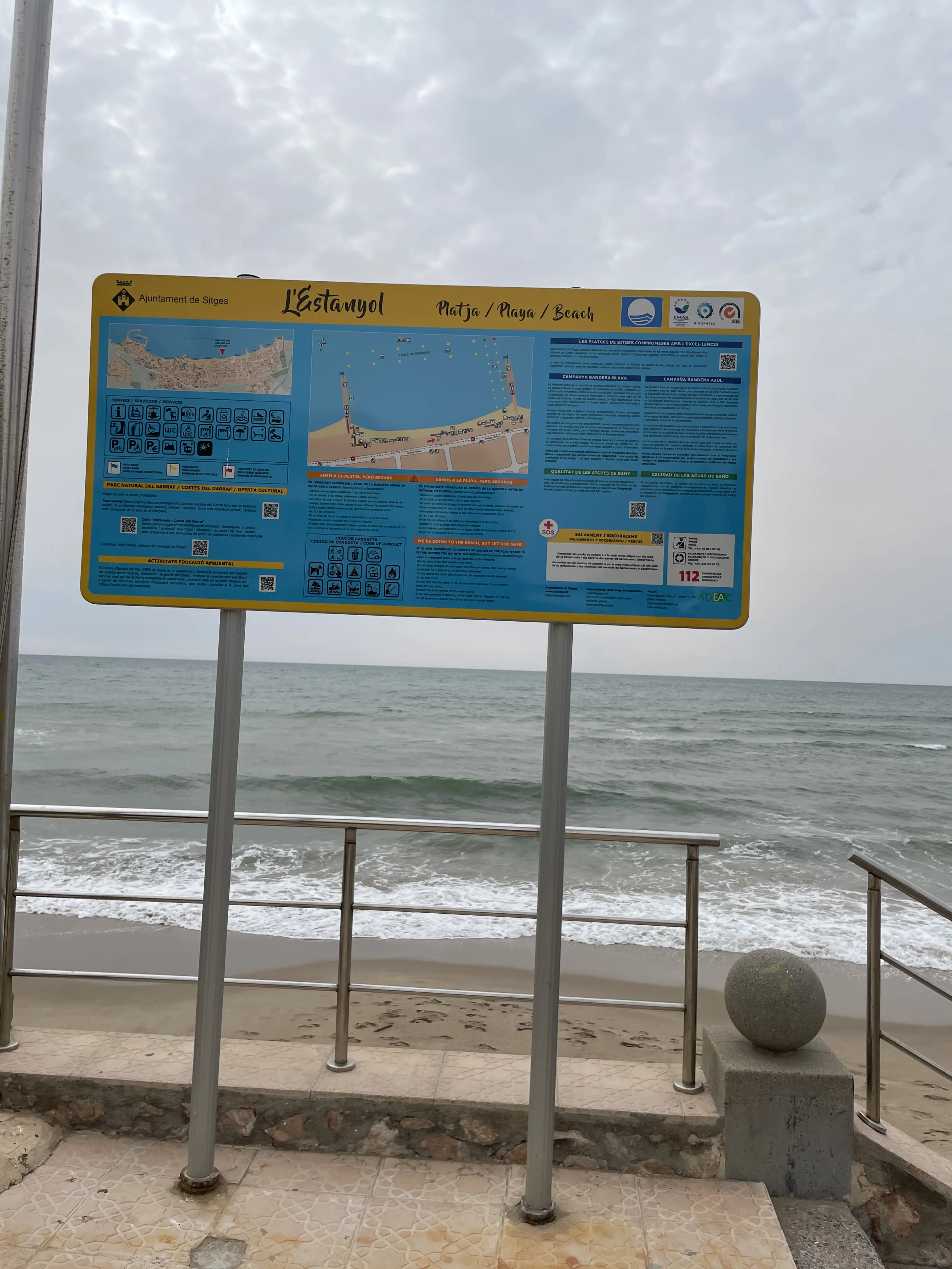 Mapa de la playa de Sitges con iconos de servicios como duchas, baños y accesos
